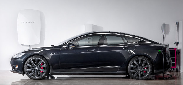 A Tesla Powerwall battery hung near a Tesla Motors car (Photo courtesy Tesla Motors. All rights reserved)