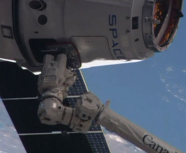 The SpaceX Dragon spacecraft grappled by the International Space Station's robotic arm Canadarm2 (Image NASA TV)