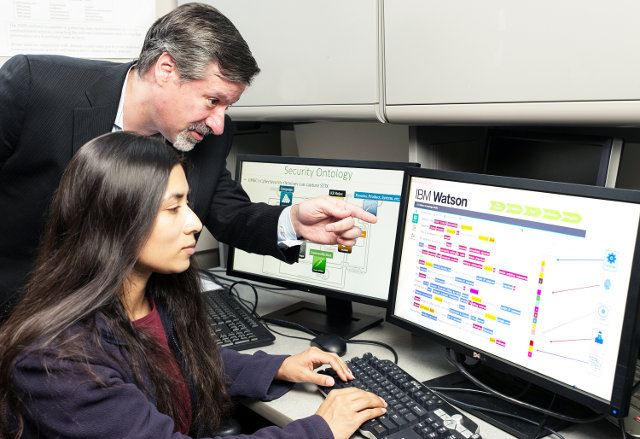 IBM’s Chief Watson Security Architect Jeb Linton demonstrating to University of Maryland Baltimore County student Lisa Mathews how to teach IBM’s Watson the language of security (Photo courtesy Mitro Hood/Feature Photo Service for IBM)