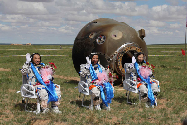 The Chinese astronauts Zhang Xiaoguang, Nie Haisheng and Wang Yaping wave to the crowd after coming out of the Shenzhou 10 spacecraft (Picture courtesy Xinhua. All rights reserved)