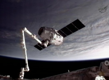 The SpaceX Dragon spacecraft grabbed by the International Space Station robot arm (Photo NASA TV)