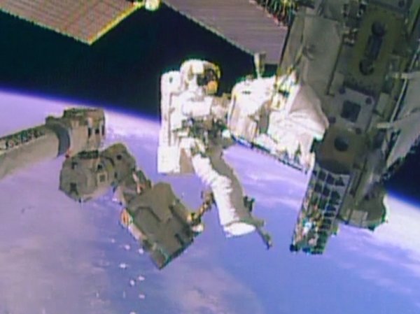 Astronaut Mike Hopkins near the Canadarm2 robotic arm during the spacewalk performed together with Rick Mastracchio (Image NASA TV)